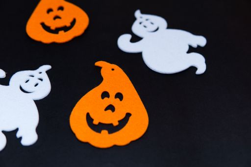 Black background with figures of ghosts, pumpkins and Halloween witches, with copy space