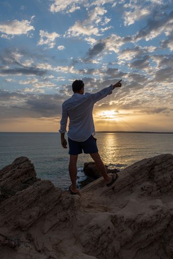 The Young man in a white shirt in Calo d es Mort on the island of Formentera in Spain
