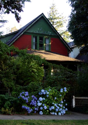 A vertical shot of a house decorated with flowers and ivy plants