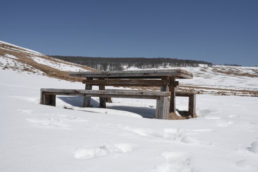 The wooden benches with a table in a field covered by snow in Ponor, Old Mountains, Serbia
