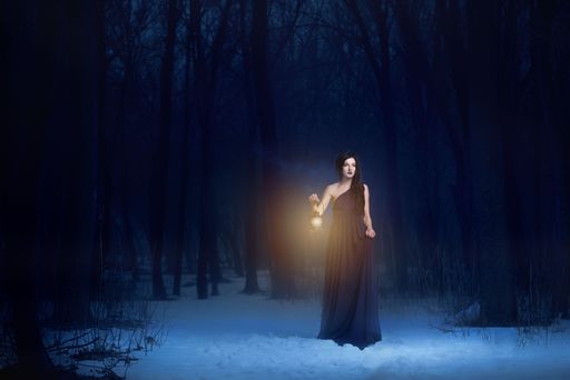 A woman in a dark dress holding a lantern in a snowy forest at night, creating a mysterious atmosphere.
