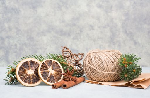 Christmas items like dried oranges, hazelnuts, fir branch on a textured background, empty copy space