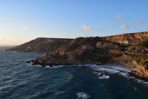 Clay slopes formed by blue clay weathering and erosion by sea at Fomm ir-Rih Bay, Malta. A popular and peaceful bay with pebble beach and blue sea