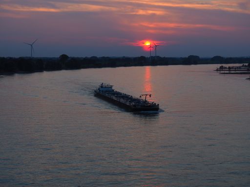 An empty ship on the sea water under a cloudy sky during the beautiful sunset