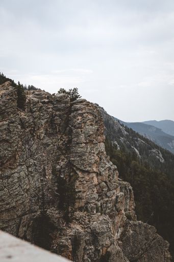 A mesmerizing view of rocky and forested mountains under the blue sky