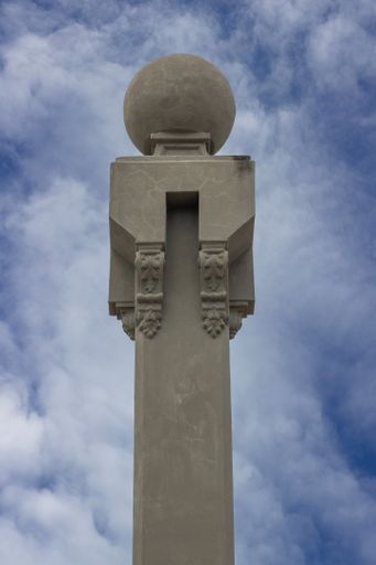 A vertical shot of a stone monument against a cloudy sky