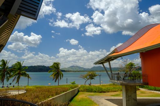The Biomuseo surrounded by greenery and the sea under a cloudy sky in Panama