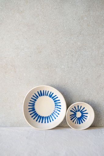 Two white ceramic dishes with a blue radiating design.