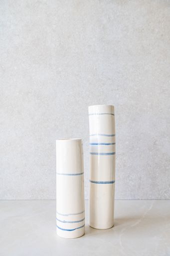 Minimalist ceramic vases with blue stripes.