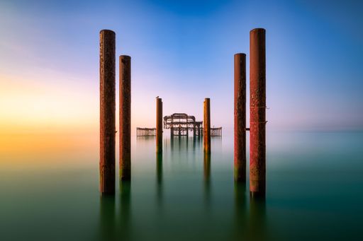 A long exposure of the West Pier in Brighton, UK, showcasing its derelict structure against the sea.