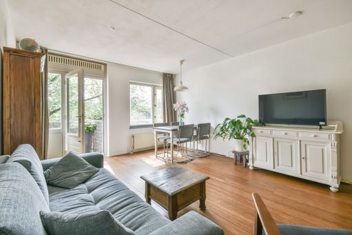 An interior shot of a living room with nice furniture in white walls and wooded floor