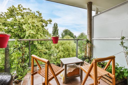 A beautiful shot of a modern balcony with wooden chairs and plants