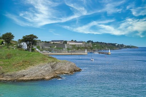 Typical harbor scene in Belle-Ile, Brittany, showing the lighthouse and old fortress.