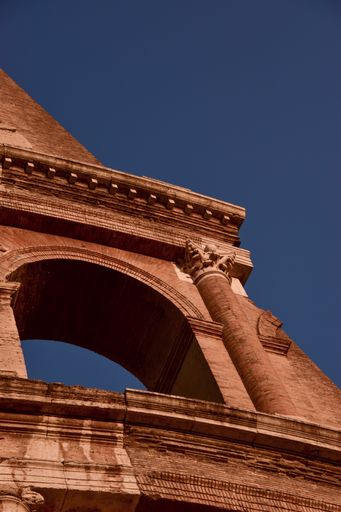A vertical low angle of an old monument against blue sky in Rome, Italy