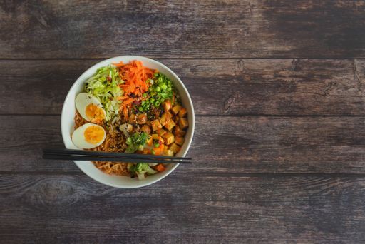 A top view of homemade ramen soup on a wooden table