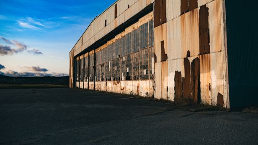 An abandoned building with broken glass windows
