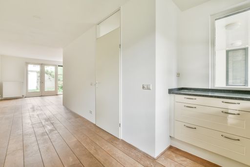 A beautiful renovated empty room interior with white walls and wooden floors
