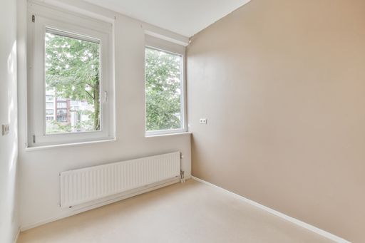 A beautiful renovated empty room interior with windows and wooden floors