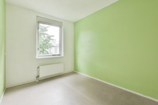 A beautiful renovated empty room interior with white green walls and wooden floors