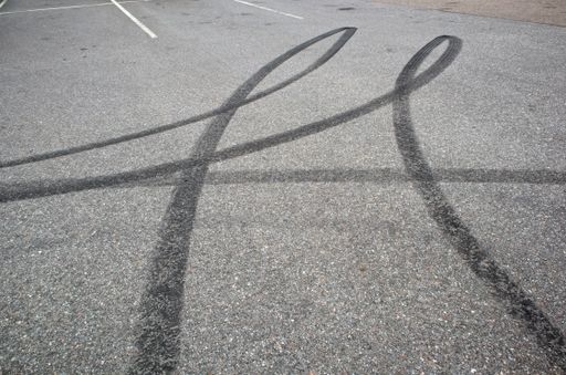 A view of Black tire marks on the parking lot asphalt