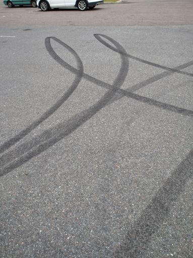 A view of Black tire marks on the parking lot asphalt