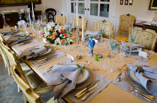 Several glasses, plates, forks, knives and napkins on the table