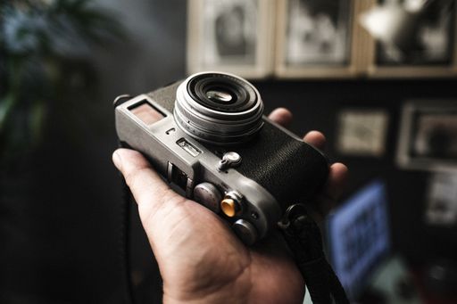 A man holding an old, vintage camera on a blurred background