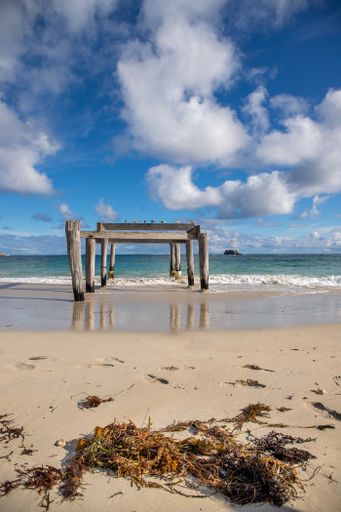 A beautiful shot of a beach being washed off by the waves of a sea under the cloudy skies