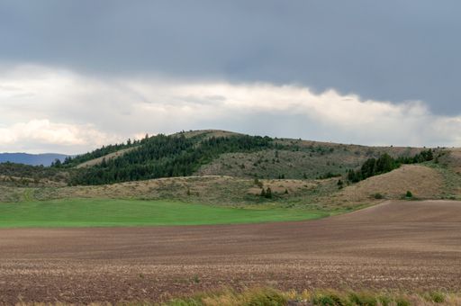 A beautiful view of a mountainous landscape with greenery under a cloudy sky
