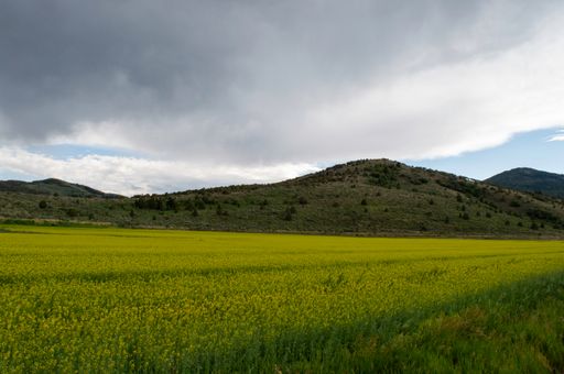 A beautiful view of a mountainous landscape with greenery under a cloudy sky