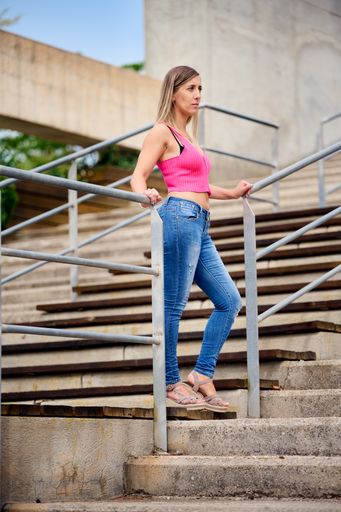 A vertical shot of a Spanish female standing on the stairs