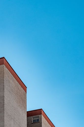 A low angle shot of stone buildings roof against the blue sky