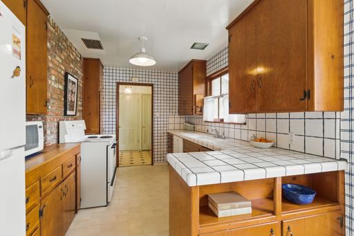 Mid-century style home featuring retro kitchen, wood-paneled living room, cozy bedrooms, and charming vintage bathrooms.
