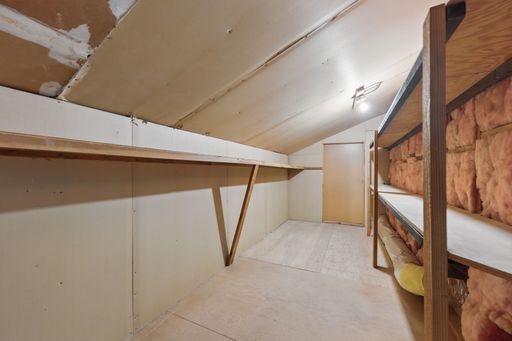 The under-construction Interior Layout of a small room with wooden floor and ceiling, white lamp and door in the background