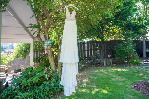 A bridal dress hanging from the tree outdoors - wedding concept