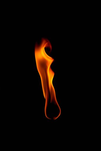 A vertical shot of a fire flame isolated on a black background