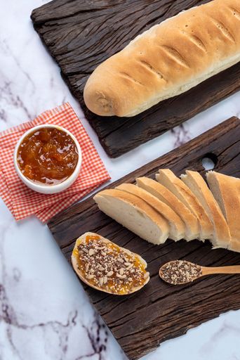 A vertical shot of a breakfast board with sliced bread and jam