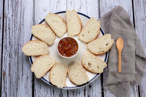 A closeup shot of a breakfast board with sliced bread and jam