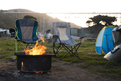 A campfire with folding chairs around it