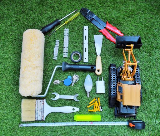A top view of many different tools for working on the green grass