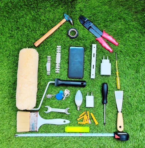 A top view of many different tools for working on the green grass