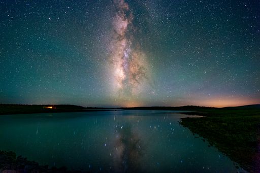 The beautiful starry night sky above a lake and landscape