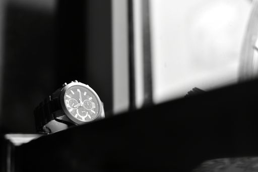 A grayscale, close-up shot of an elegant silver watch