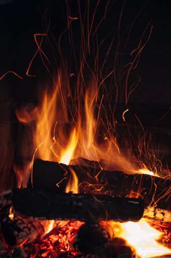 A vertical shot of the wood burning in a beautiful bonfire in the dark.