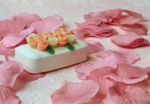 A handmade soap with roses on a background of rose petals