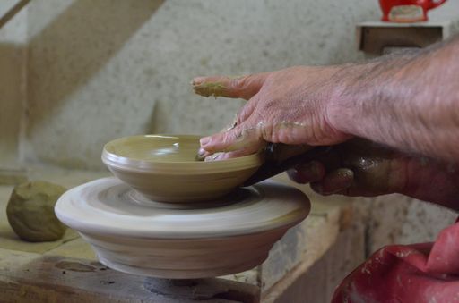 A selective focus shot of a person making  pottery with clay