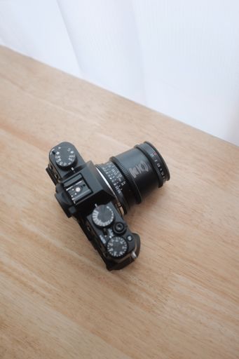 An overhead shot of a camera on a wooden surface