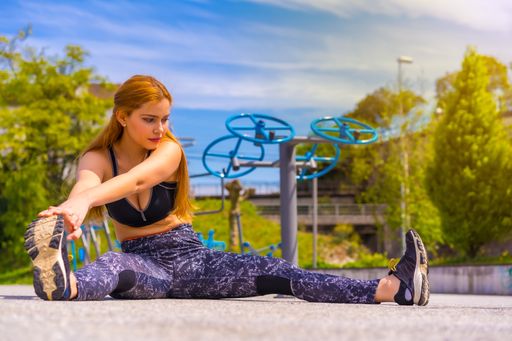 A young redhead Hispanic lady in sportswear enjoying the sunny day exercising in a park