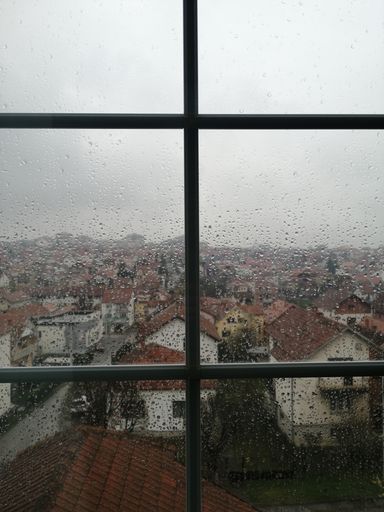 A cityscape from a window on a rainy day