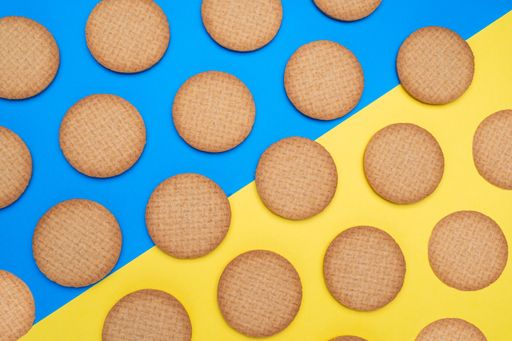 A top view shot of circular cookies on a blue and yellow surface